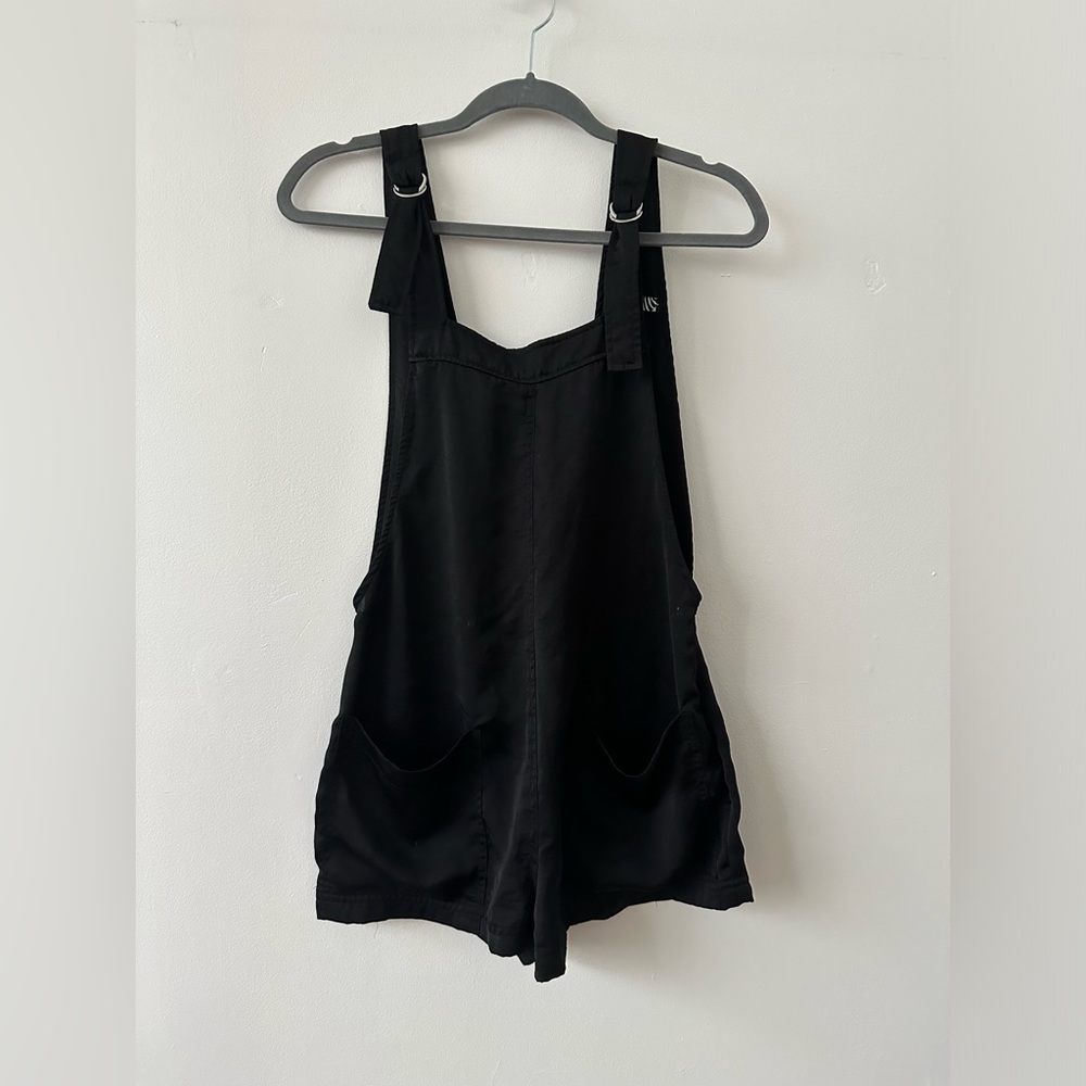 Overall romper black with front pockets and open back Bershka
